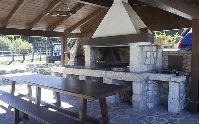 agriturismo-rio-torto-foto-03 Area barbecue in pietra dell’Agriturismo Alfedena Abruzzo, perfetta per grigliate in compagnia tra i profumi del legno e la quiete della natura.