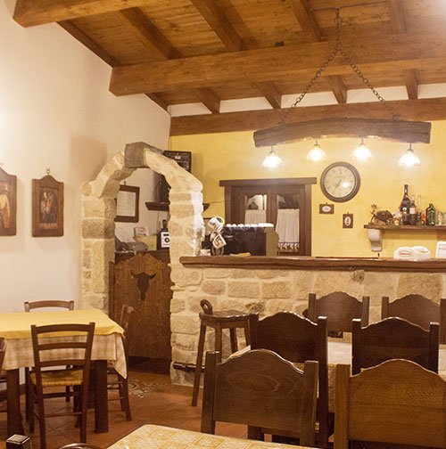 agriturismo-rio-torto-foto-q-03 Interno rustico dell’Agriturismo Alfedena Abruzzo, con bancone in pietra e luci calde: il luogo ideale per sentirsi a casa, tra gusto e tradizione.