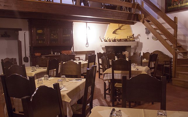 agriturismo-rio-torto-foto-ristorante-3 Sala interna del ristorante tipico Alfedena con camino decorato e soppalco: il gusto di un’esperienza conviviale tra le tradizioni d’Abruzzo.